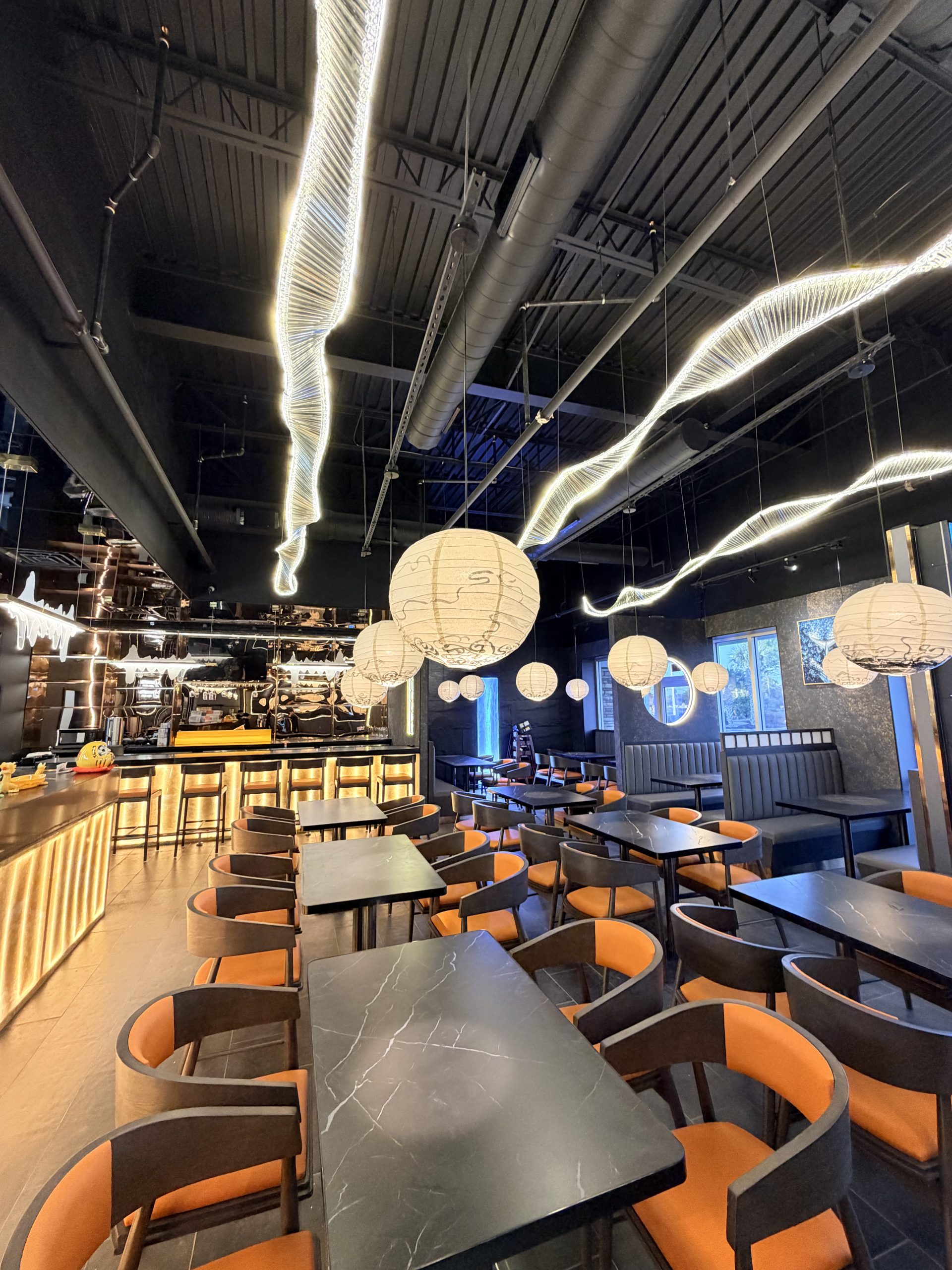 Modern sushi bar interior with dark tones and warm lighting at Rakisuta Modern Sushi, Japanese Restaurant in Rockledge